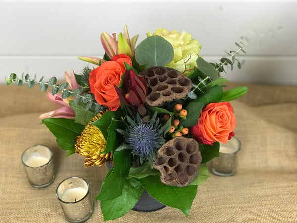 Another warm, rustic design. Similar to the Centerpiece design of Regina's Rustic Thanksgiving but in a smaller more versatile container. Still filled with warm tones and texture including lilies, hydrangea, kale, thistle, eucalyptus, roses, leucadendron, and hypericum.  Instead of the traditional long and low design, this cylinder tin allows for multiple down the table or spread throughout the house.  Done by Gig Morris Florist in Belmar, New Jersey.