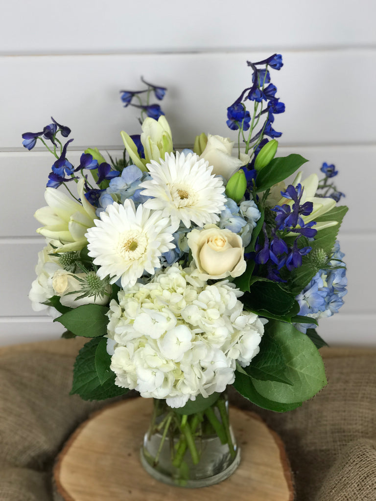 white and blue flowers create a sense of the beach with florals that include hydrangea, Gerber daisies, delphinium, lilies, roses and thistle
