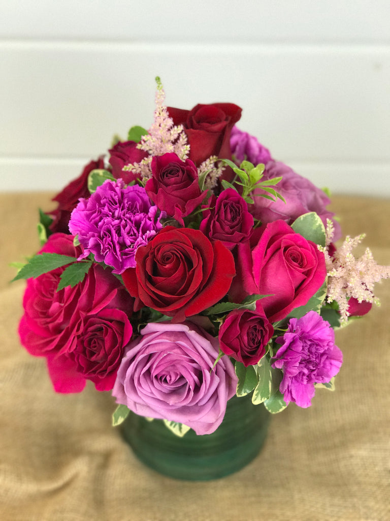 Roses in pinks, lavenders, purples, reds in vase arrangement by a flower shop in Belmar, New Jersey