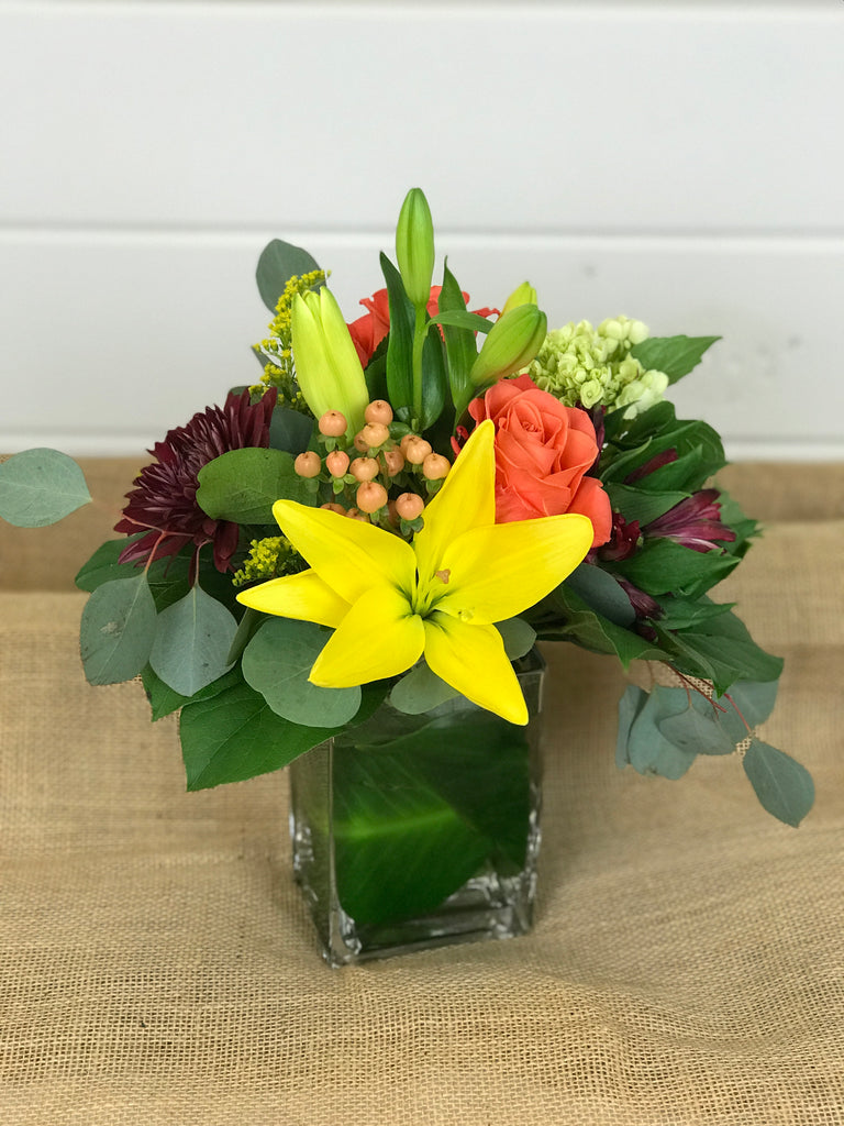 Fall Thanksgiving glass centerpiece floral arrangements done by Gig Morris Florist in Belmar, New Jersey. Filled with lilies, roses, hypericum berries, mums and hydrangea