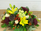 Thanksgiving floral centerpiece for a table from Gig Morris Florist in Belmar, New Jersey. Consists of fall colors with mums, lilies, hydrangea, roses, and magnolia leaves
